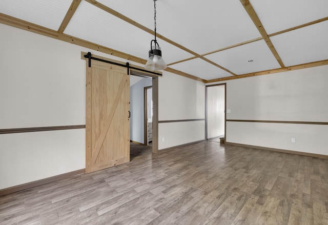 spare room featuring hardwood / wood-style floors and a barn door