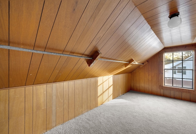 additional living space with lofted ceiling, wood walls, wood ceiling, and light carpet