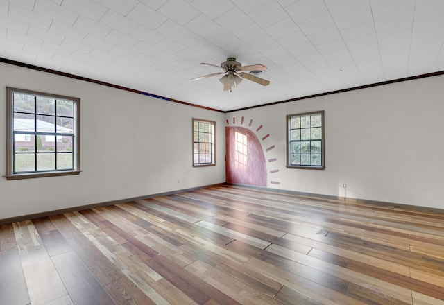 empty room featuring hardwood / wood-style flooring, ceiling fan, and ornamental molding