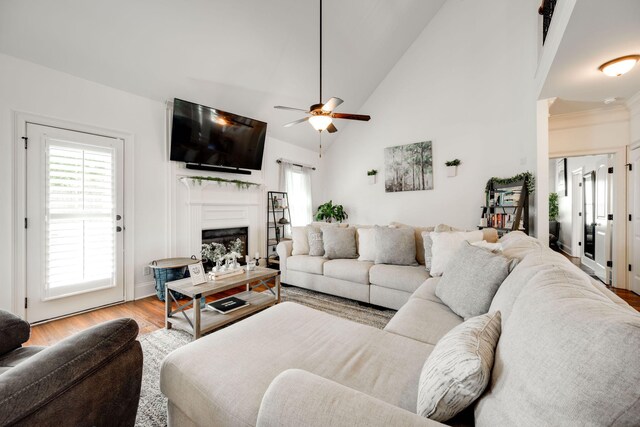 living room with ceiling fan, high vaulted ceiling, and light hardwood / wood-style floors