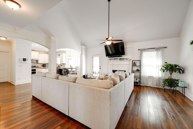 living room with ceiling fan, dark hardwood / wood-style flooring, and high vaulted ceiling