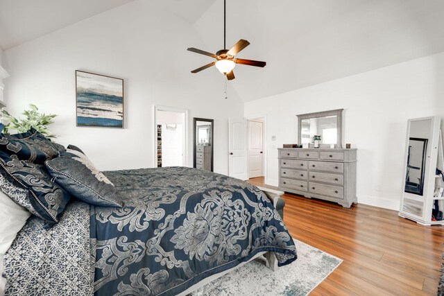 bedroom featuring ceiling fan, wood-type flooring, ensuite bathroom, and high vaulted ceiling