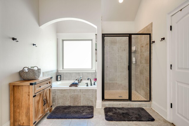 bathroom with tile patterned flooring, separate shower and tub, and lofted ceiling