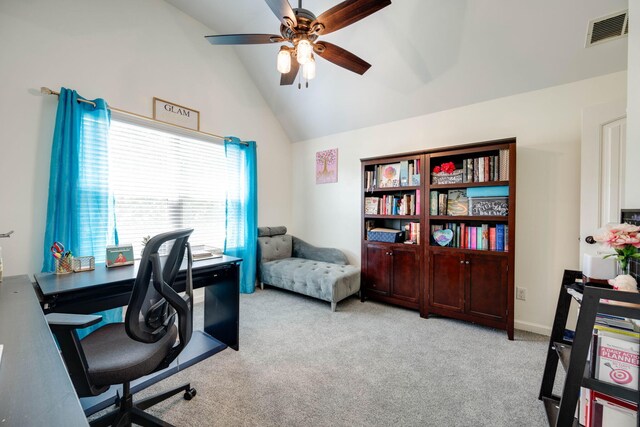 carpeted home office with ceiling fan and vaulted ceiling