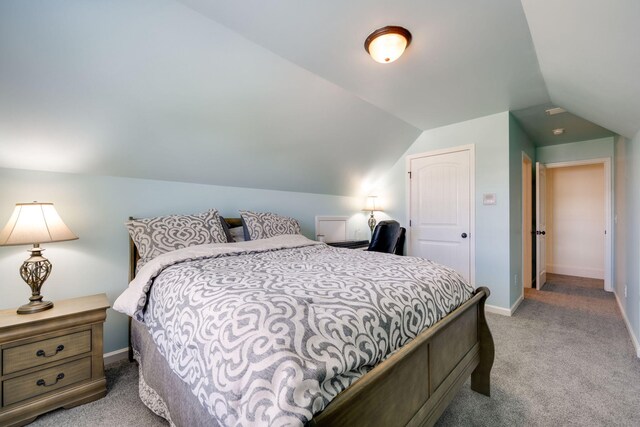 bedroom featuring lofted ceiling and light carpet