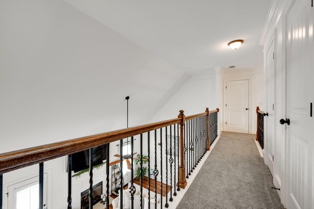 hall with light carpet and vaulted ceiling