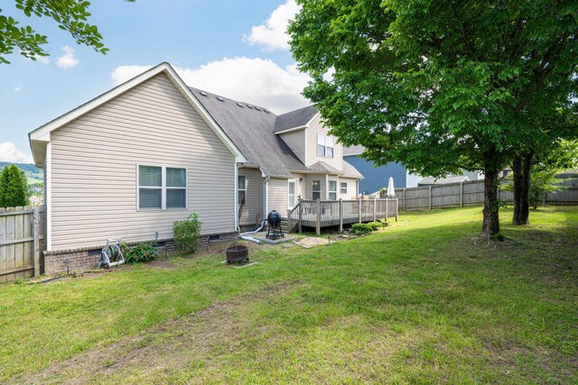 rear view of house featuring a yard and a wooden deck