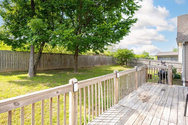 wooden terrace with a yard and grilling area