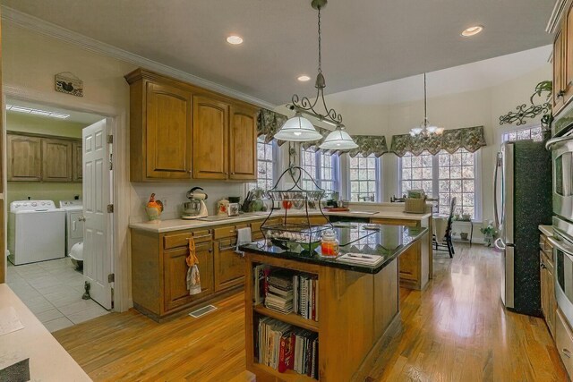 289 Magnolia Pl, Ringgold, GA 30736 - kitchen with independent washer and dryer, brown cabinets, a kitchen island, light wood finished floors, and recessed lighting