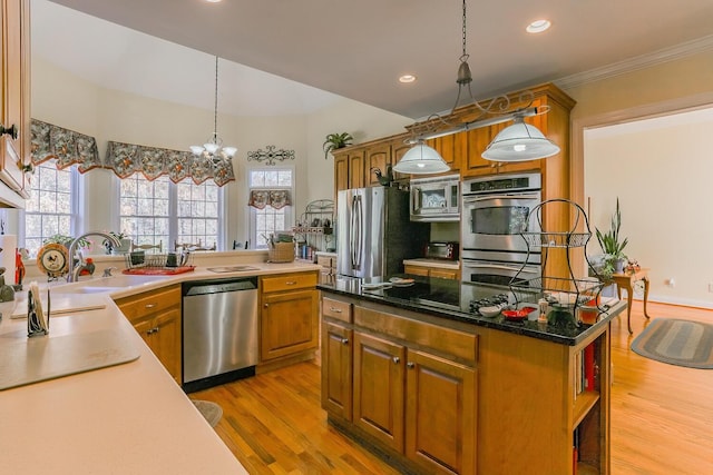 289 Magnolia Pl, Ringgold, GA 30736 - kitchen with stainless steel appliances, light wood-style floors, brown cabinetry, healthy amount of natural light, and crown molding