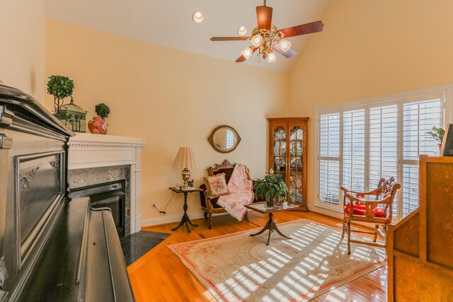 289 Magnolia Pl, Ringgold, GA 30736 - sitting room featuring a fireplace with flush hearth, a ceiling fan, high vaulted ceiling, wood finished floors, and baseboards