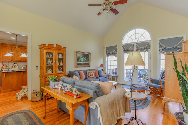 living room with ceiling fan, light hardwood / wood-style flooring, and high vaulted ceiling