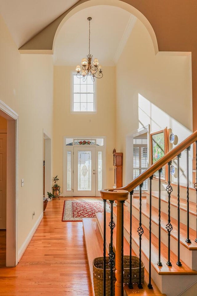 289 Magnolia Pl, Ringgold, GA 30736 - entryway featuring a chandelier, light wood-type flooring, a towering ceiling, arched walkways, and crown molding