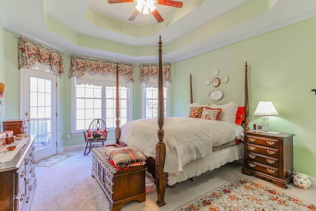 bedroom featuring access to outside, light colored carpet, ceiling fan, crown molding, and a tray ceiling