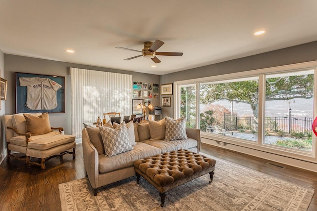 living room featuring ceiling fan and dark hardwood / wood-style flooring