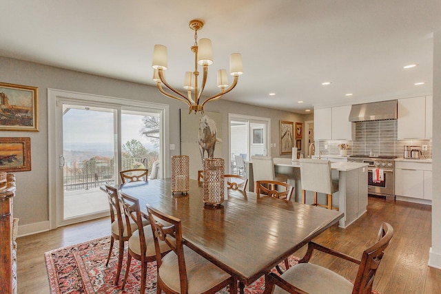 dining space with hardwood / wood-style flooring and a notable chandelier