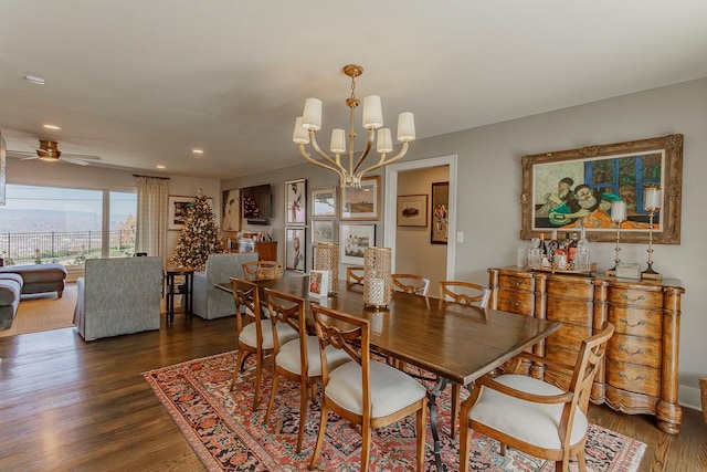 dining room with ceiling fan with notable chandelier and dark hardwood / wood-style floors