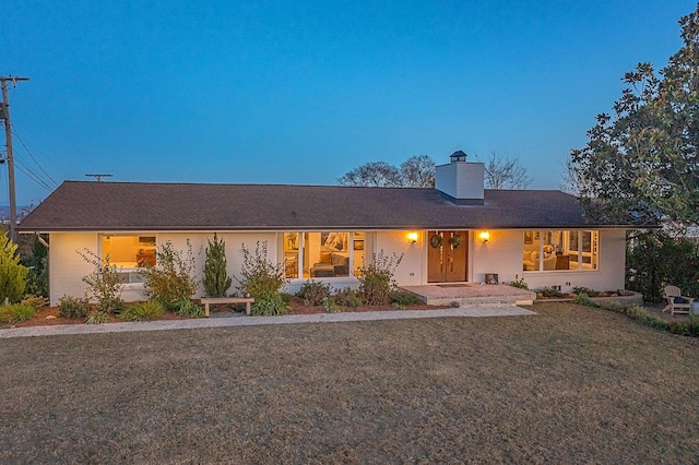 single story home featuring a lawn