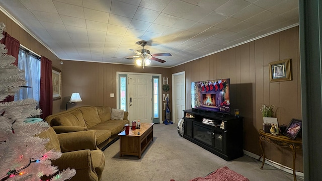 carpeted living room featuring crown molding and ceiling fan