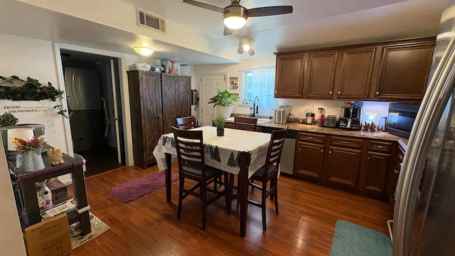 kitchen featuring stainless steel appliances, ceiling fan, dark brown cabinets, and dark wood-type flooring