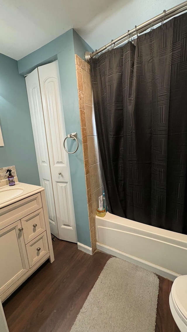 full bathroom with vanity, wood-type flooring, shower / tub combo, and toilet