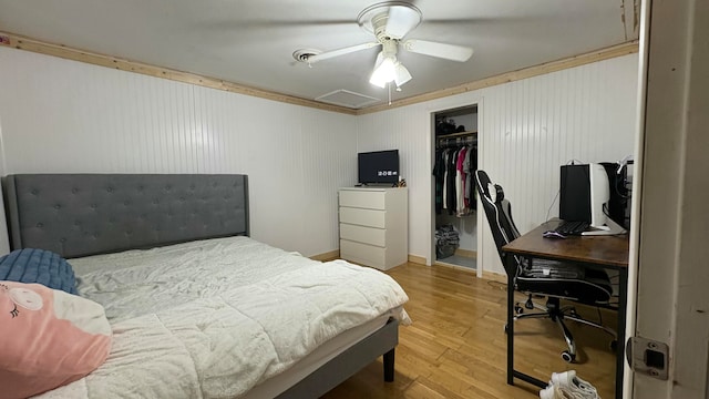 bedroom with hardwood / wood-style flooring, ceiling fan, a spacious closet, and a closet