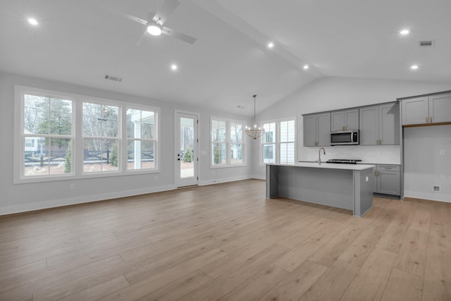 kitchen with gray cabinetry, a kitchen island with sink, and light hardwood / wood-style flooring