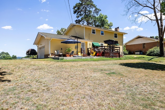 back of house with a yard, a deck, and a garage