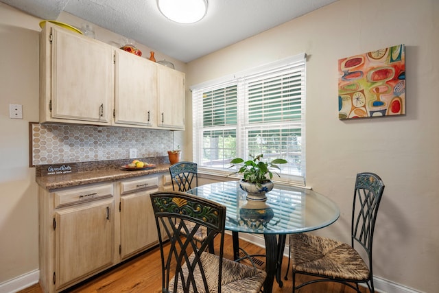 kitchen with decorative backsplash, light brown cabinets, and light hardwood / wood-style floors