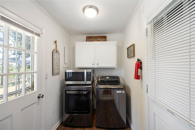 laundry area featuring hardwood / wood-style flooring, cabinets, separate washer and dryer, and ornamental molding