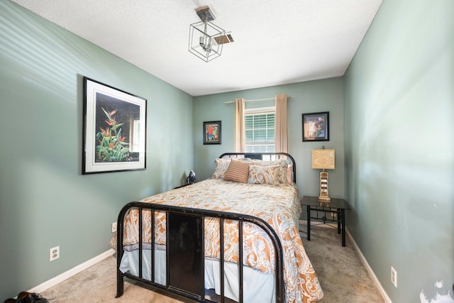 bedroom featuring light carpet and a textured ceiling