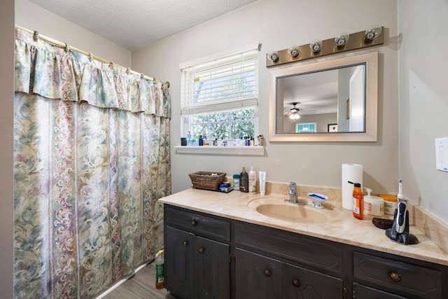 bathroom featuring vanity, hardwood / wood-style flooring, ceiling fan, a textured ceiling, and walk in shower