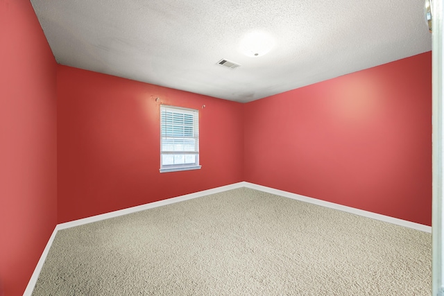 carpeted empty room with a textured ceiling