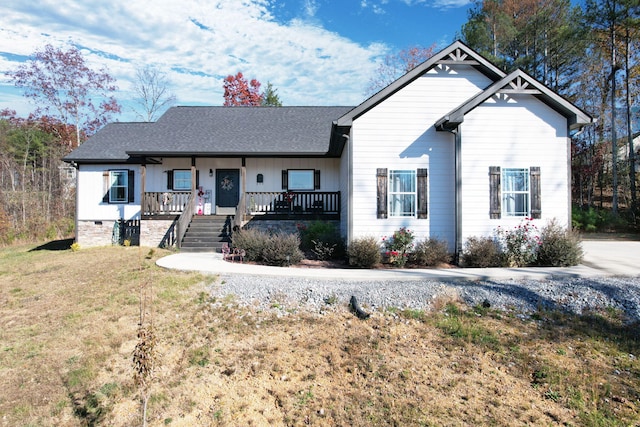 view of front of house featuring covered porch and a front lawn