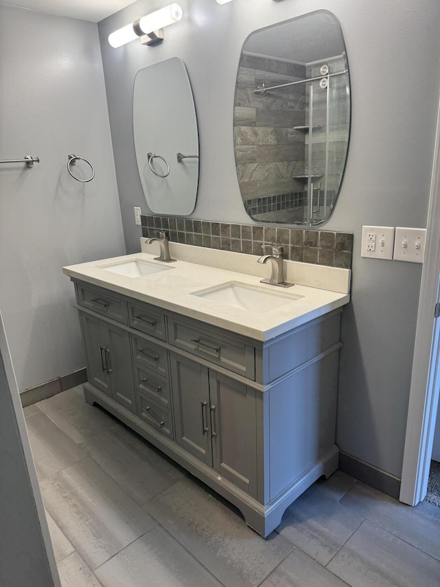 bathroom featuring tile patterned flooring, vanity, backsplash, and a shower