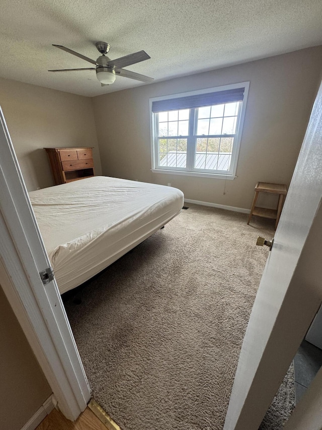 bedroom with a textured ceiling, ceiling fan, and carpet floors