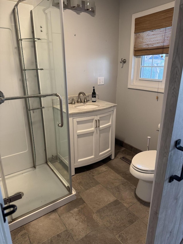 bathroom featuring toilet, a shower with door, and vanity