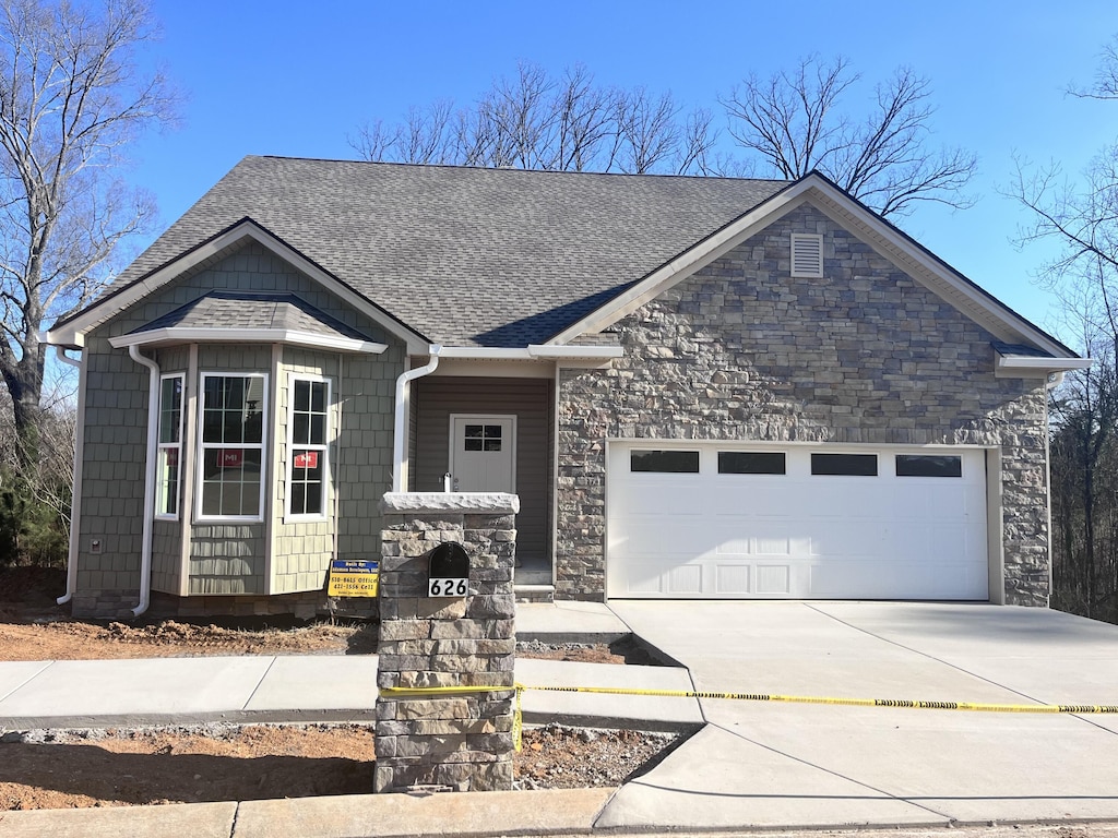 626 Harvey Ln, Chattanooga, TN 37411 - view of front of property with a garage, roof with shingles, stone siding, and concrete driveway