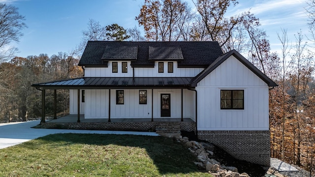 modern farmhouse featuring a porch and a front yard