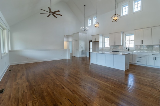 kitchen featuring hanging light fixtures, white cabinetry, dark wood-type flooring, and high vaulted ceiling