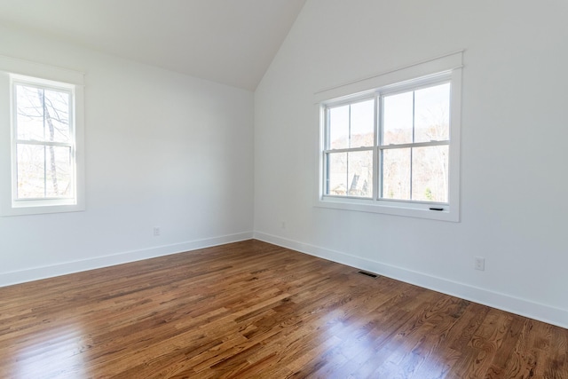 unfurnished room with hardwood / wood-style floors and vaulted ceiling