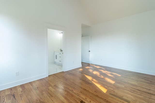 unfurnished room featuring wood-type flooring and sink