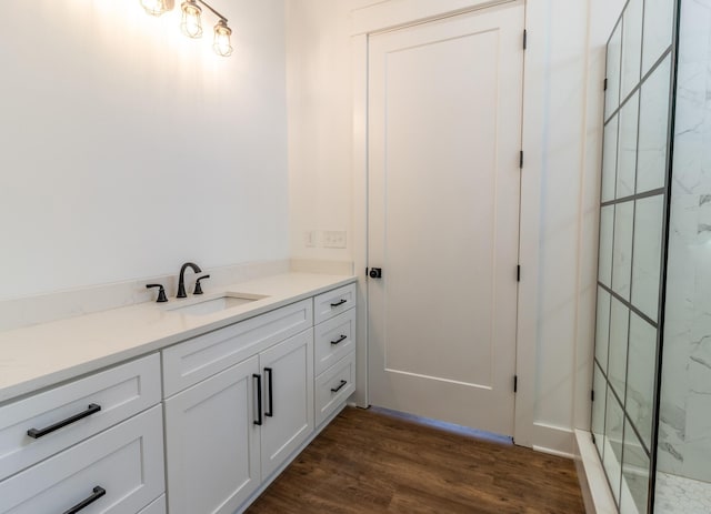 bathroom featuring tiled shower, wood-type flooring, and vanity