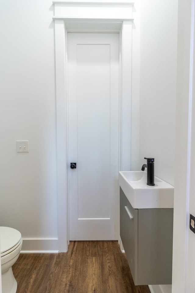 bathroom with hardwood / wood-style floors, vanity, and toilet