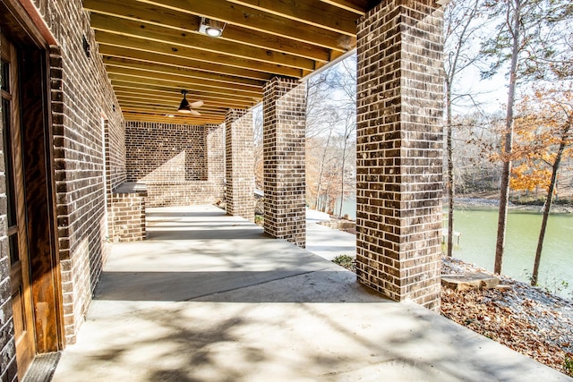 view of patio with ceiling fan and a water view