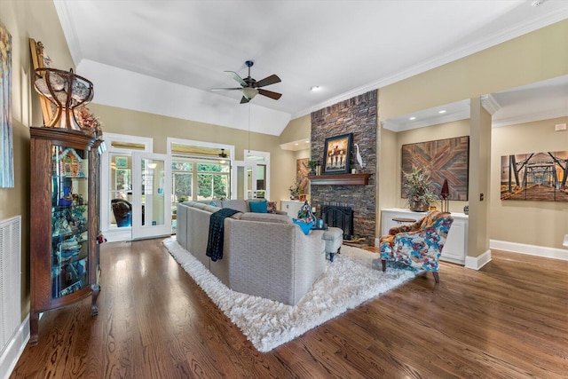 living room featuring dark hardwood / wood-style floors, a fireplace, lofted ceiling, ornamental molding, and ceiling fan