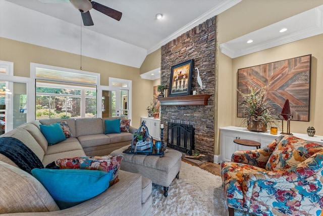 living room with a stone fireplace, wood-type flooring, lofted ceiling, ornamental molding, and ceiling fan