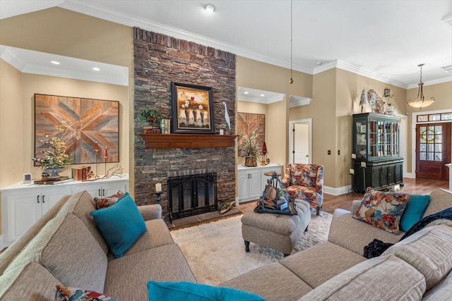 living room with crown molding, a stone fireplace, and light hardwood / wood-style floors