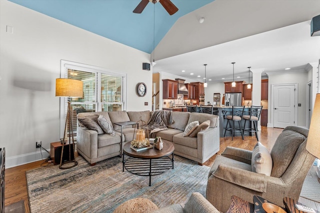 living room featuring ceiling fan, vaulted ceiling, and light hardwood / wood-style floors