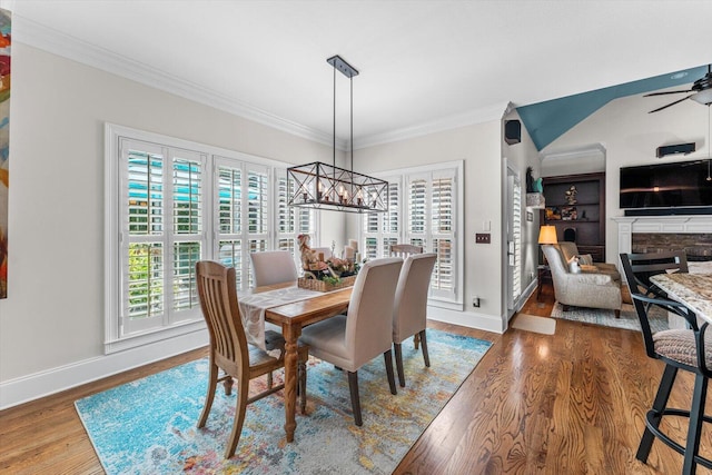 dining room featuring hardwood / wood-style floors, ceiling fan with notable chandelier, and ornamental molding